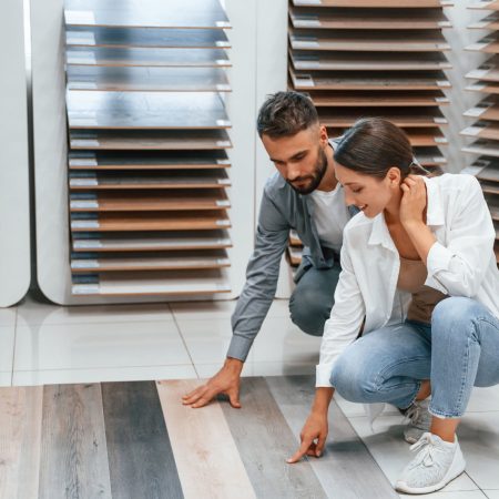 Choosing parquet. Woman and man is in the store of goods for the home.